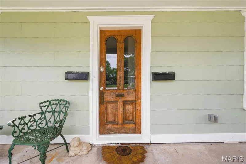 Distressed wood-finish front door with glass panels, white trim, and a brass-tone doorknob — 502 S Linn Avenue, Wentzville, MO 63385