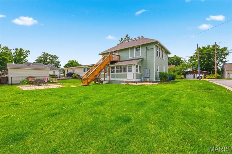 Expansive green lawn with a two-story exterior featuring light green siding and white trim — 502 S Linn Avenue, Wentzville, MO 63385