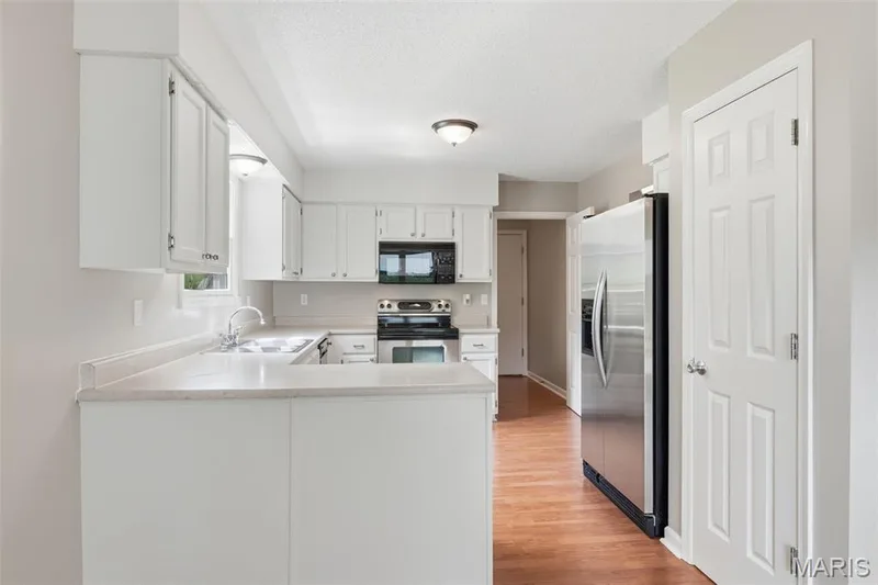 Kitchen featuring white cabinetry, light-toned countertops, a stainless steel appliances — 814 Emerald Place Drive, St Charles, MO 63304