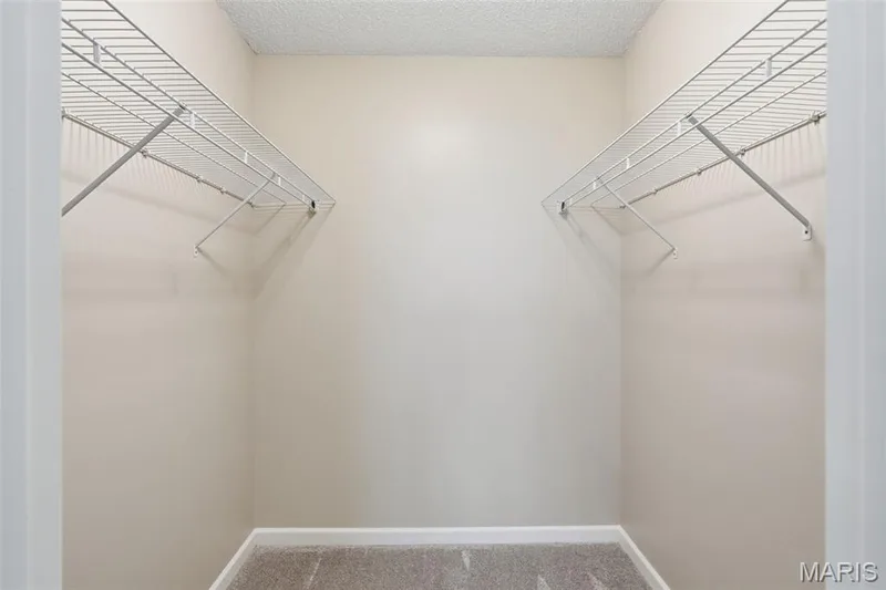 Walk-in closet with wire shelving and recently installed carpet — 814 Emerald Place Drive, St Charles, MO 63304