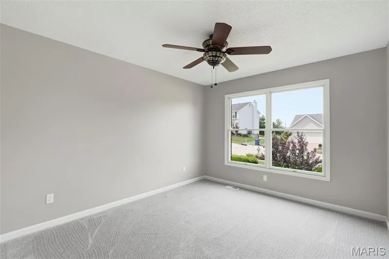 Spacious bedroom featuring freshly painted walls, a large window, and ceiling fan — 814 Emerald Place Drive, St Charles, MO 63304