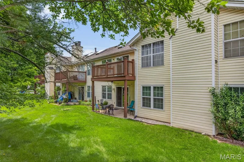 Expansive lawn area featuring a ground-level patio and an upper-level wood deck — 1034 Windstream Drive #14, St Peters, MO 63376