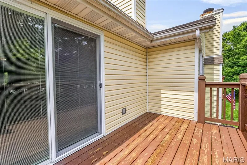 Exterior deck featuring wood flooring, brown wooden railings, and light-colored siding — 1034 Windstream Drive #14, St Peters, MO 63376