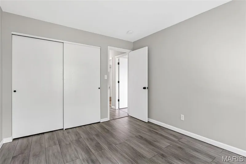 Bedroom with wood-finish flooring, light gray wall paint, and white trim — 1034 Windstream Drive #14, St Peters, MO 63376