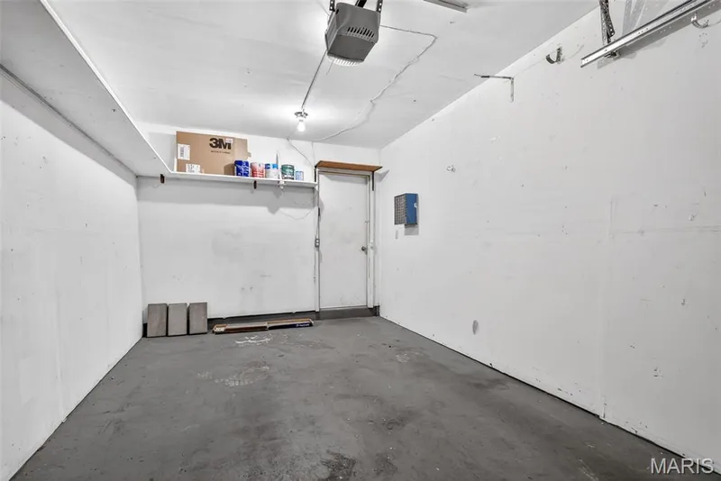 Attached garage featuring a concrete floor, painted walls, overhead lighting, and an overhead door opener — 1034 Windstream Drive #14, St Peters, MO 63376