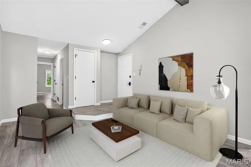 Vaulted ceiling living area featuring wood-finish flooring, recessed lighting, and a neutral color palette — 1034 Windstream Drive #14, St Peters, MO 63376