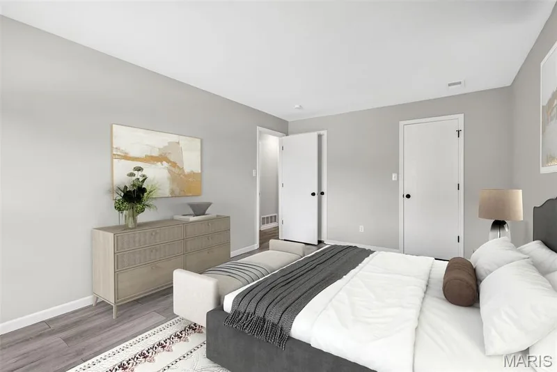 Spacious room featuring light gray walls, white trim, and wood-finish flooring — 1034 Windstream Drive #14, St Peters, MO 63376
