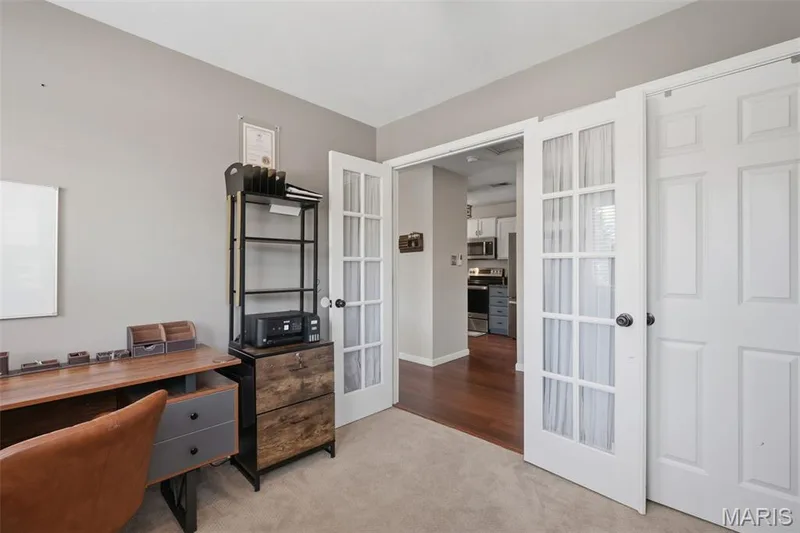Room featuring, double glass French doors,  neutral-toned walls and carpeted flooring — 704 Hemingway Lane #E, Weldon Spring, MO 63304