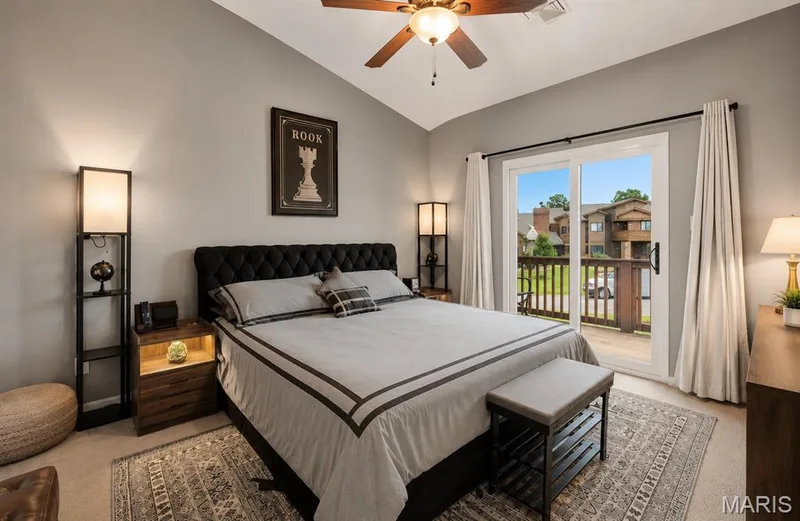 Bedroom featuring a vaulted ceiling and a sliding glass door leading to a private balcony — 704 Hemingway Lane #E, Weldon Spring, MO 63304