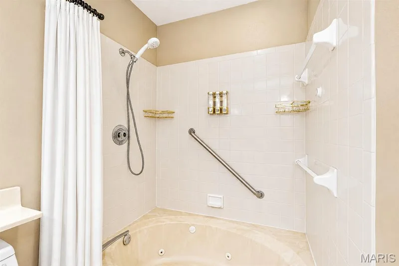 Jetted soaking tub with a handheld shower, white  tile surround — 704 Hemingway Lane #E, Weldon Spring, MO 63304