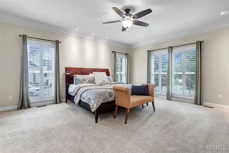 Spacious room with light-colored carpeting, multiple French doors, plantation shutters, and crown molding — 2154 White Lane Drive, Chesterfield, MO 63017