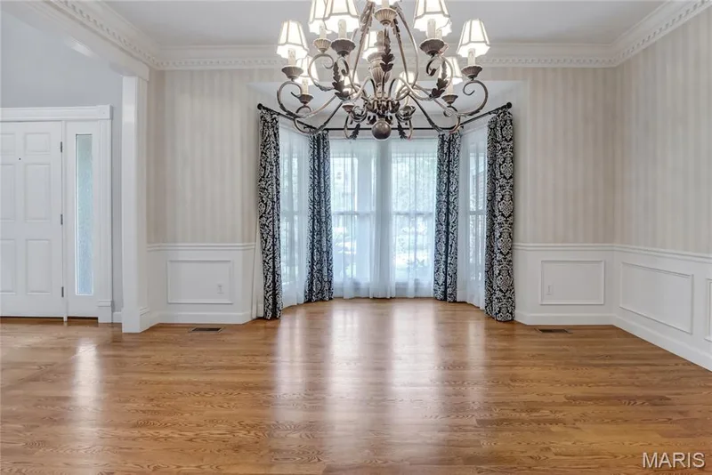 Bay window with multiple panes, hardwood flooring, crown molding, wainscoting, and an ornate chandelier — 2154 White Lane Drive, Chesterfield, MO 63017