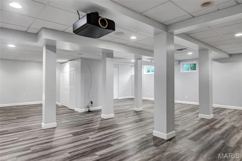 Spacious room featuring wood-finish flooring, recessed lighting, drop ceiling, and multiple windows — 2154 White Lane Drive, Chesterfield, MO 63017