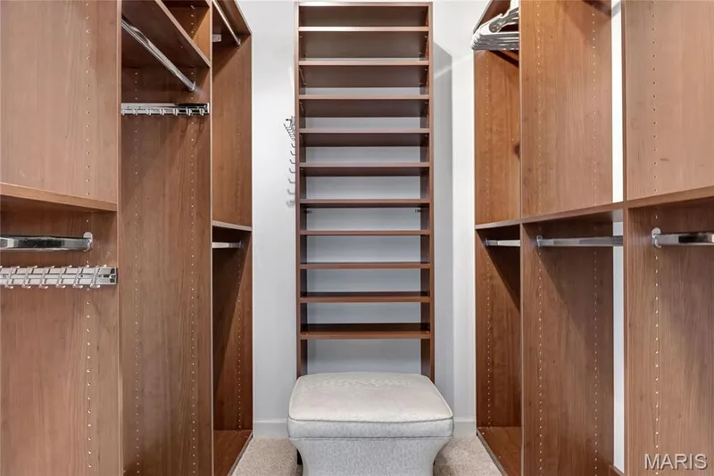Primary Custom closet system with wood-finish cabinetry, integrated shelving, and chrome hanging rods — 2154 White Lane Drive, Chesterfield, MO 63017