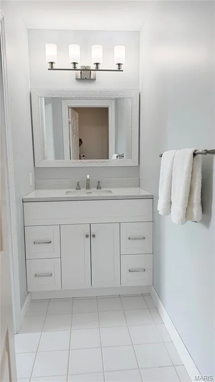 White vanity with brushed nickel hardware, integrated rectangular sink, wall-mounted mirror, and a four-light fixture — 2154 White Lane Drive, Chesterfield, MO 63017