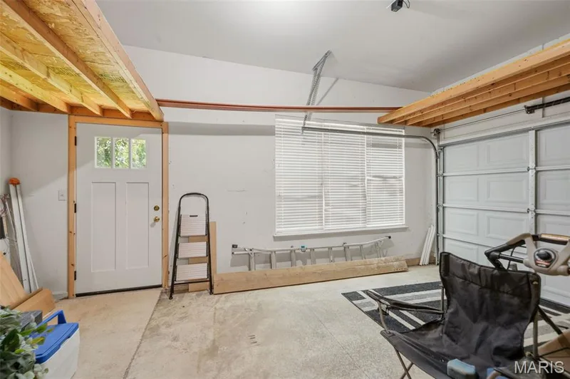 Single car side of garage with storage racks and door - perfect for another vehicle or workshop/hobby  area! — 202 Highland Meadows Drive, Wentzville, MO 63385