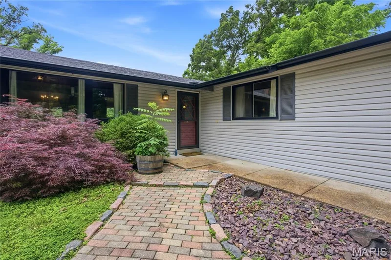 Front exterior featuring light-colored siding and a dark roofline — 1221 Shepard Road, Wildwood, MO 63038