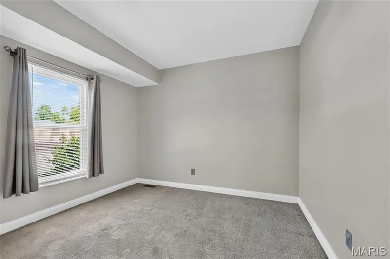 Interior room featuring neutral gray walls, light gray carpet, and white baseboards — 115 Carriage View Drive, Wildwood, MO 63040