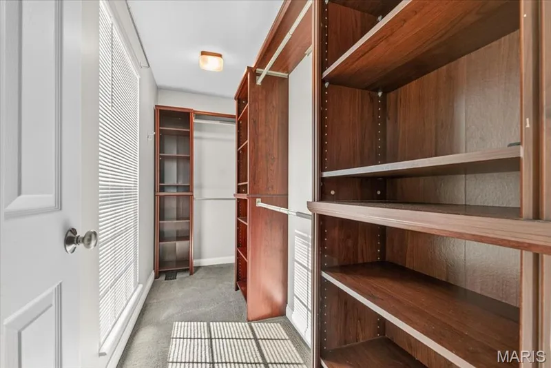 Spacious closet featuring extensive wood-finish shelving and hanging rods — 115 Carriage View Drive, Wildwood, MO 63040