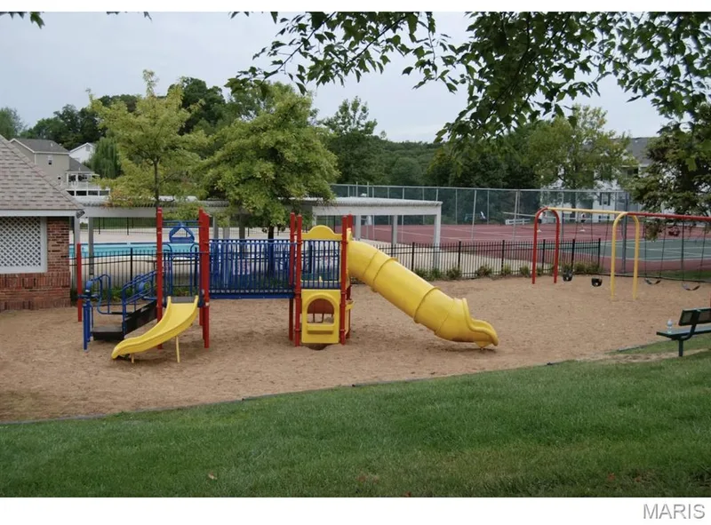 Recreational area featuring a playground with a yellow slide and swings, a fenced swimming pool, and tennis courts — 115 Carriage View Drive, Wildwood, MO 63040