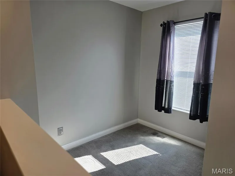 Compact room featuring light gray wall paint and gray carpet flooring — 115 Carriage View Drive, Wildwood, MO 63040