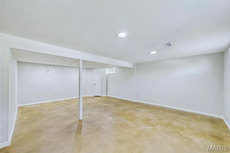 Lower level flex space featuring the HVAC, laundry, garage access, and a spacious secondary living area — 656 Nancy Drive, St Charles, MO 63301