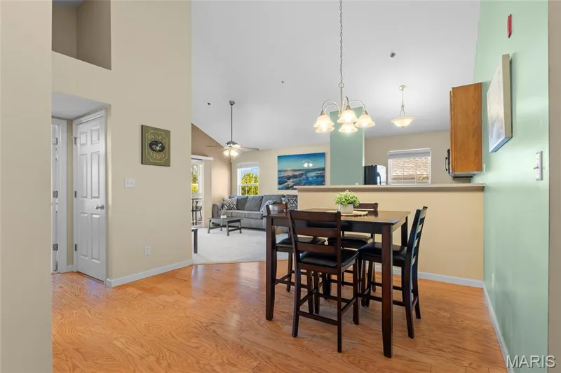 Open-concept interior featuring wood-finish flooring, a breakfast bar, and recessed lighting — 1233 Saravalle Drive, St Peters, MO 63376