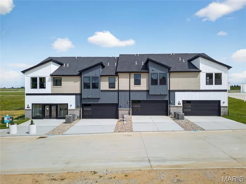 Modern farmhouse featuring a shingled roof, driveway, an attached garage, and stone siding — 172 Sesame Loop, St Peters, MO 63303