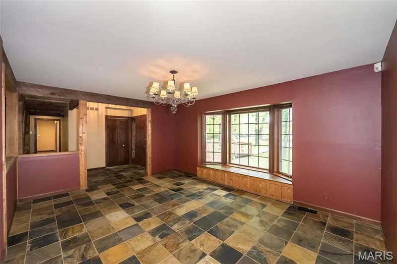 Unfurnished dining area featuring a chandelier, dark stone finish flooring, and baseboards — 2731 Christy Avenue, Wildwood, MO 63040