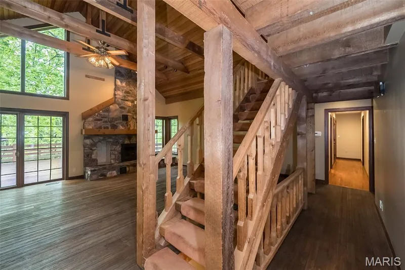 Stairway featuring wood finished floors, beam ceiling, wood ceiling, a stone fireplace, and high vaulted ceiling — 2731 Christy Avenue, Wildwood, MO 63040