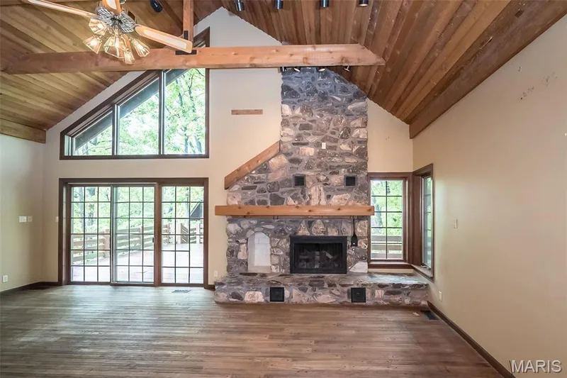 Unfurnished living room with high vaulted ceiling, wooden ceiling, wood finished floors, beam ceiling, and a fireplace — 2731 Christy Avenue, Wildwood, MO 63040