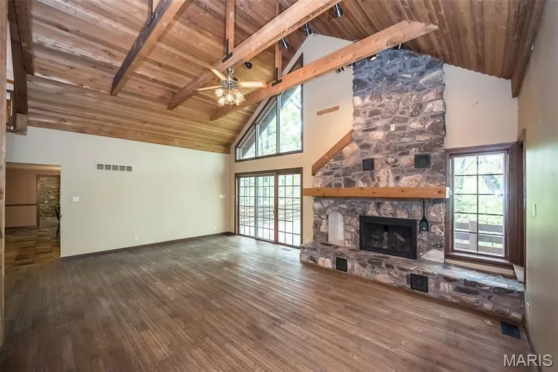 Unfurnished living room with wooden ceiling, high vaulted ceiling, wood-type flooring, a fireplace, and a ceiling fan — 2731 Christy Avenue, Wildwood, MO 63040