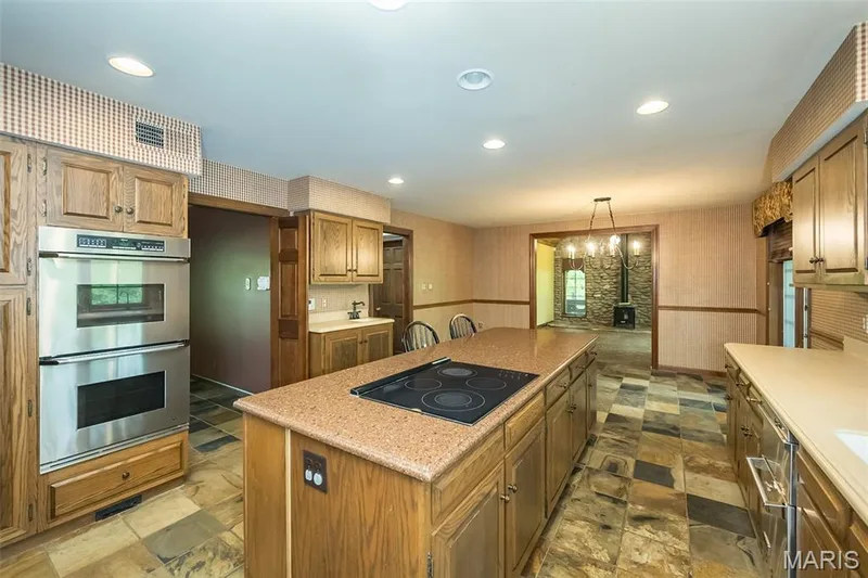 Kitchen featuring stainless steel double oven, black electric cooktop, a kitchen island, dark stone finish flooring, and recessed lighting — 2731 Christy Avenue, Wildwood, MO 63040