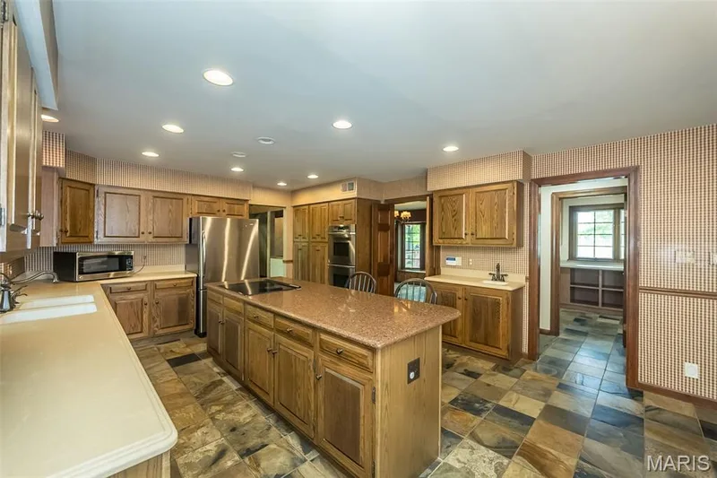 Kitchen with a sink, stainless steel appliances, a kitchen island, light countertops, and recessed lighting — 2731 Christy Avenue, Wildwood, MO 63040