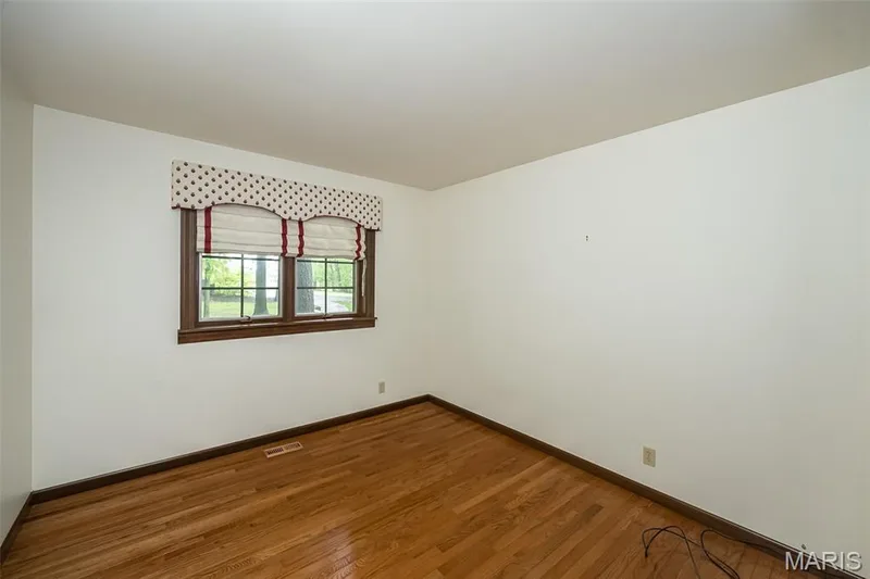 Unfurnished room with baseboards and wood finished floors — 2731 Christy Avenue, Wildwood, MO 63040