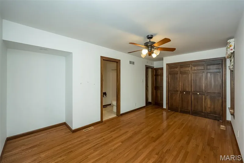 Unfurnished bedroom with light wood-style flooring, baseboards, connected bathroom, and ceiling fan — 2731 Christy Avenue, Wildwood, MO 63040