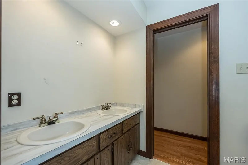 Bathroom with double vanity, wood finished floors, and baseboards — 2731 Christy Avenue, Wildwood, MO 63040