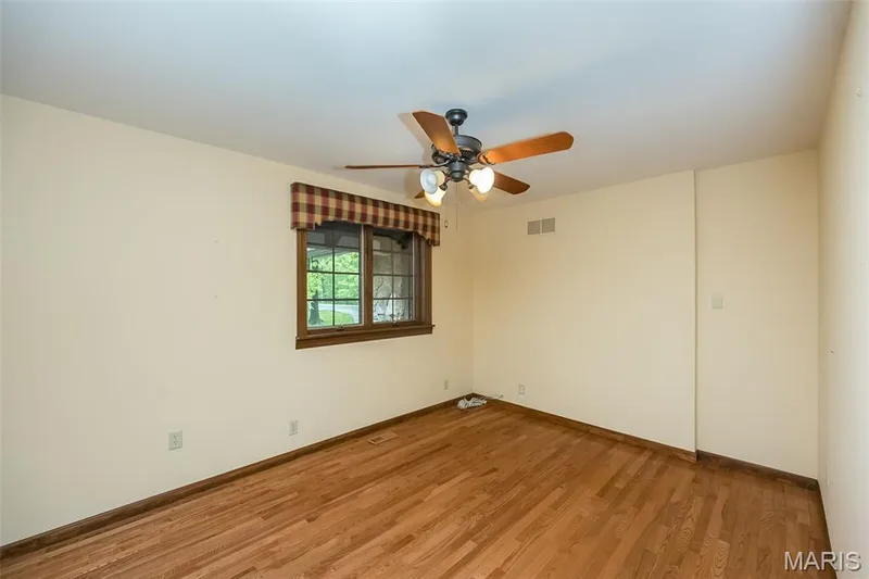 Unfurnished room featuring a ceiling fan, light wood-type flooring, and baseboards — 2731 Christy Avenue, Wildwood, MO 63040