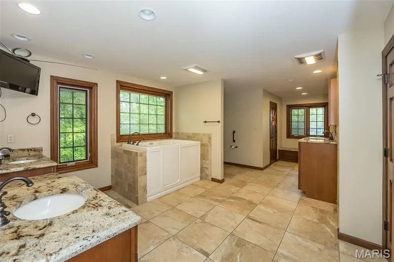 Bathroom with recessed lighting, two vanities, baseboards, healthy amount of natural light, and a bath — 2731 Christy Avenue, Wildwood, MO 63040