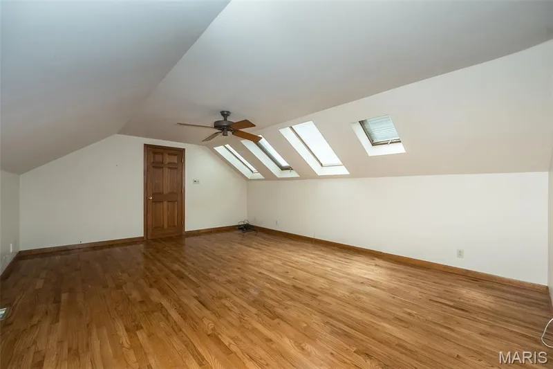 Bonus room featuring a skylight, light wood-style flooring, lofted ceiling, and baseboards — 2731 Christy Avenue, Wildwood, MO 63040