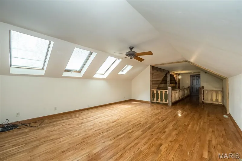 Bonus room featuring a skylight, wood finished floors, lofted ceiling, ceiling fan, and baseboards — 2731 Christy Avenue, Wildwood, MO 63040