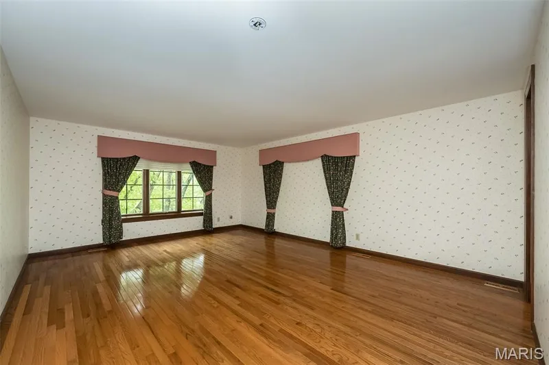 Unfurnished room with wallpapered walls, hardwood / wood-style floors, and baseboards — 2731 Christy Avenue, Wildwood, MO 63040
