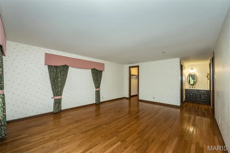 Empty room with wallpapered walls and wood-type flooring — 2731 Christy Avenue, Wildwood, MO 63040
