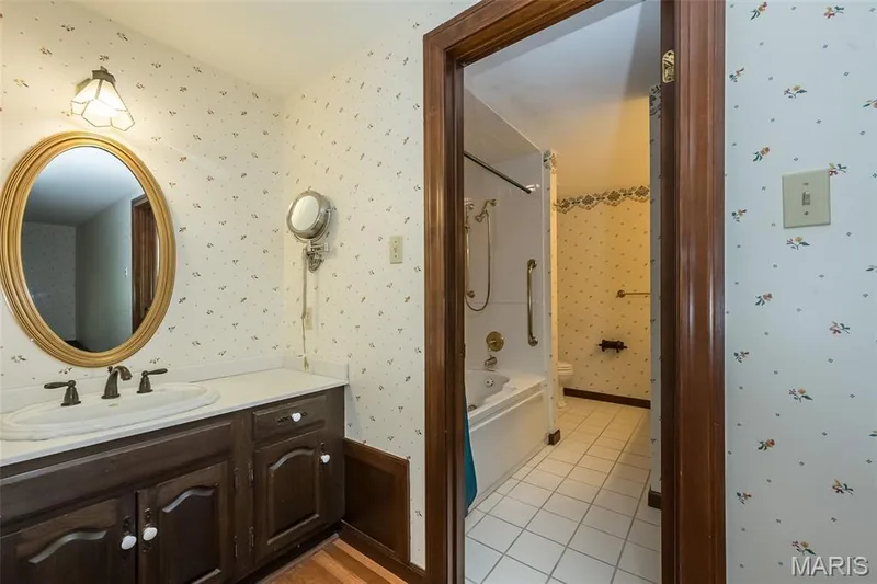 Bathroom with toilet, wallpapered walls, tile patterned flooring, vanity, and shower / bathtub combination — 2731 Christy Avenue, Wildwood, MO 63040