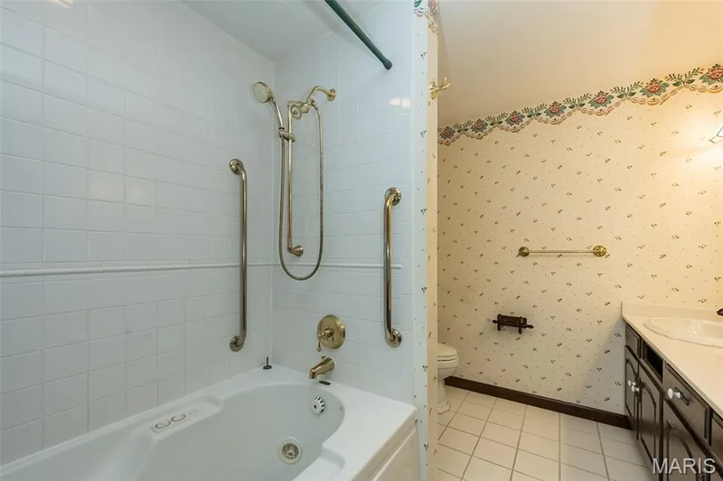 Bathroom featuring shower / washtub combination, vanity, toilet, tile patterned flooring, and baseboards — 2731 Christy Avenue, Wildwood, MO 63040