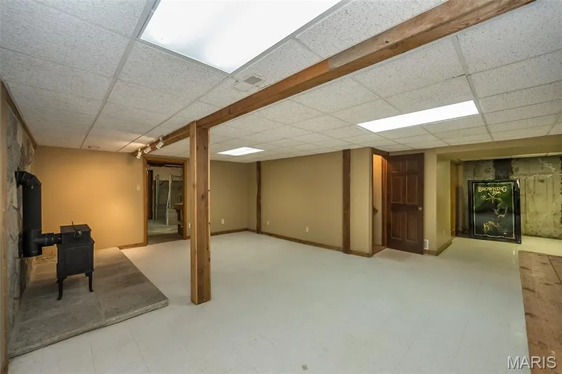 Finished basement featuring a paneled ceiling and a wood stove — 2731 Christy Avenue, Wildwood, MO 63040