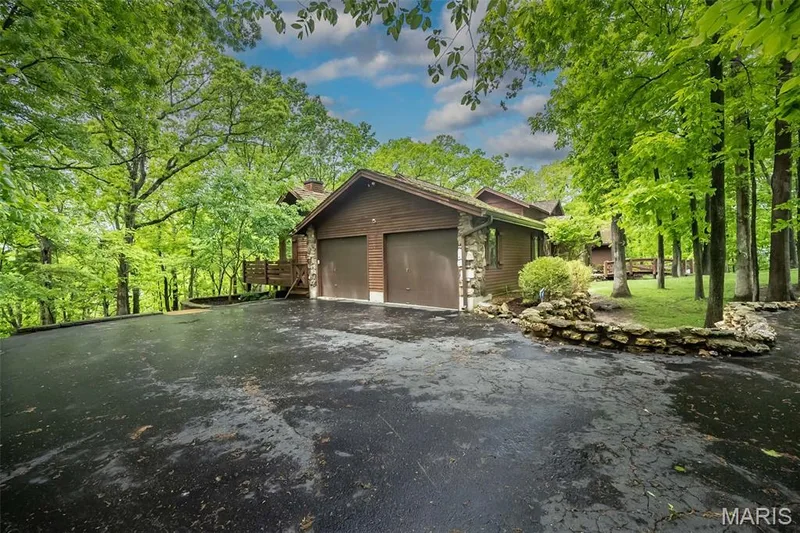 View of side of home featuring a chimney, asphalt driveway, and a garage — 2731 Christy Avenue, Wildwood, MO 63040