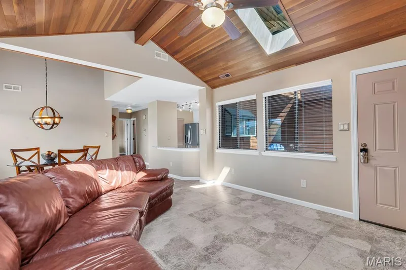 Vaulted wood-paneled ceiling with exposed beams, skylight, and ceiling fan — 309 Hemingway Lane, Weldon Spring, MO 63304