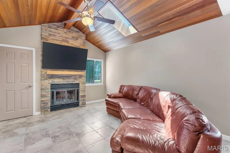 Vaulted wood-finish ceiling with an integrated ceiling fan and skylight — 309 Hemingway Lane, Weldon Spring, MO 63304