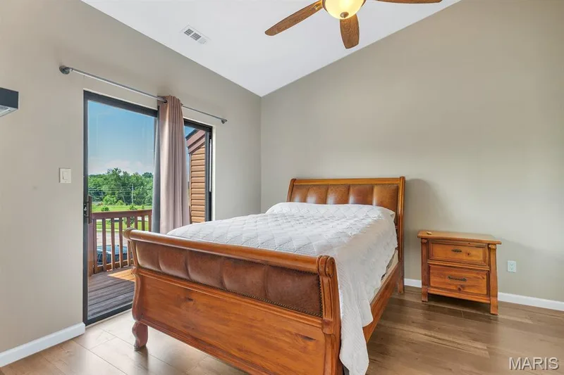 Sliding glass door opening to an exterior balcony with wooden railings — 309 Hemingway Lane, Weldon Spring, MO 63304